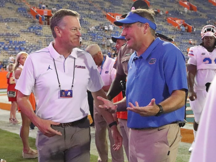 Scott Stricklin talks with Dan Mullen after a Gators win